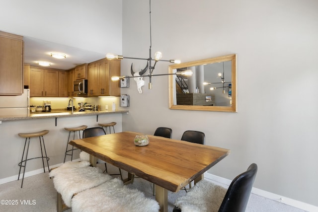 dining room featuring a notable chandelier and baseboards