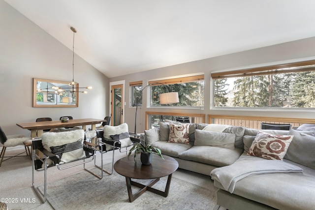 living area with light carpet, plenty of natural light, high vaulted ceiling, and an inviting chandelier