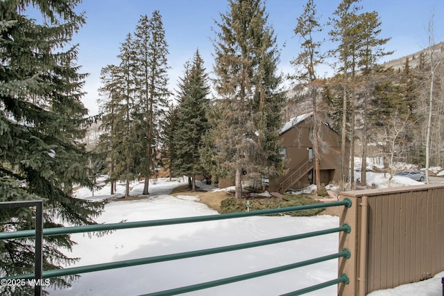 yard covered in snow featuring a balcony