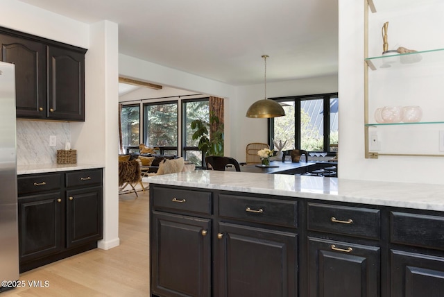 971 Winslow Rd, Edwards, CO 81632 - kitchen featuring light wood-style floors, decorative backsplash, healthy amount of natural light, and light stone counters