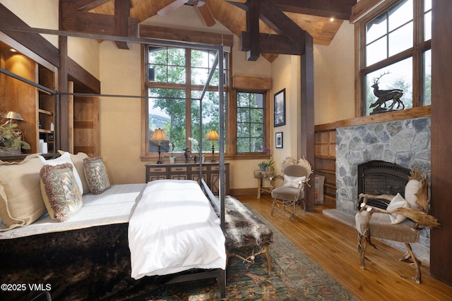 780 Potato Patch Dr, Vail, CO 81657 - bedroom featuring hardwood / wood-style flooring, multiple windows, a stone fireplace, beam ceiling, and high vaulted ceiling