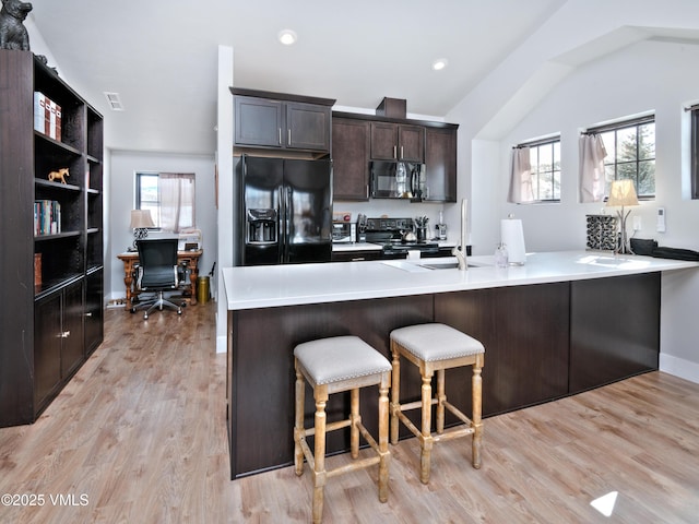 4 E Dewey Park, Eagle, CO 81631 - kitchen with black appliances, a kitchen bar, dark brown cabinets, healthy amount of natural light, and vaulted ceiling