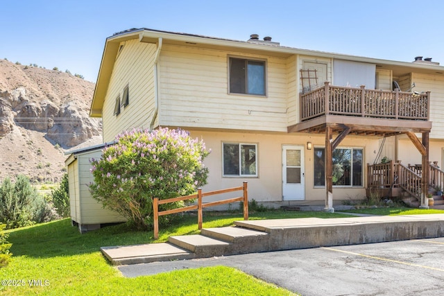 600 Price Ln Unit 1, Gypsum, CO 81637 - rear view of property with a balcony, uncovered parking, a lawn, and a mountain view
