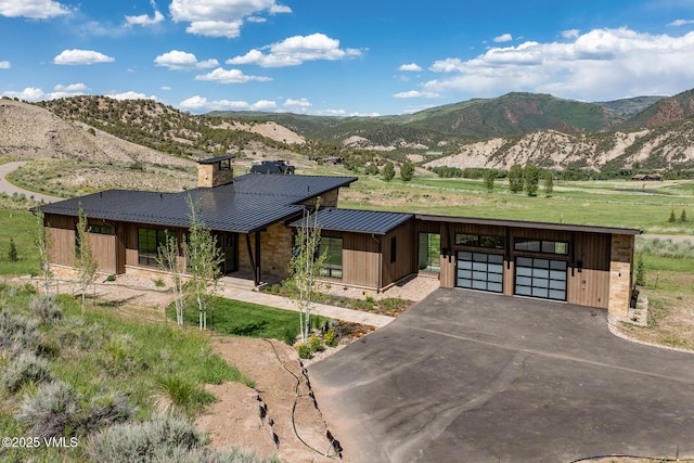 0599 Gray Rock Dr, Eagle, CO 81631 - view of front of property featuring a standing seam roof, a chimney, driveway, a mountain view, and a metal roof
