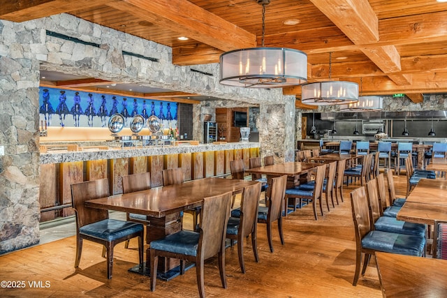 dining room with beamed ceiling, wood ceiling, and hardwood / wood-style floors