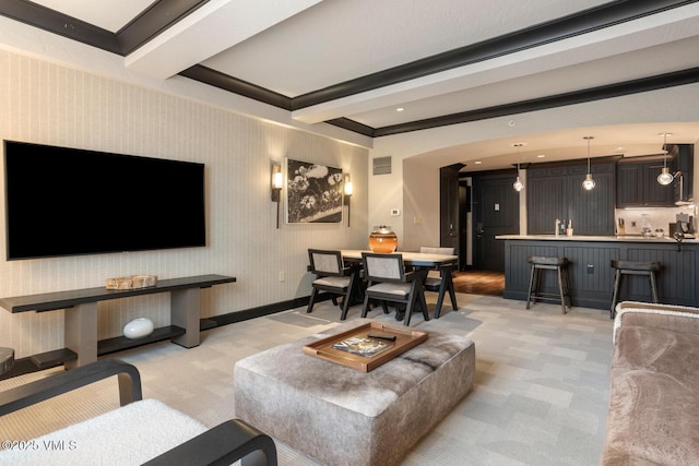 living room with beamed ceiling and light colored carpet