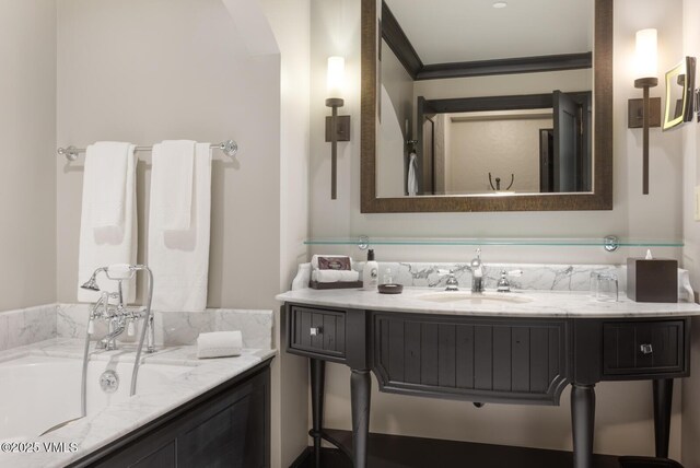 bathroom featuring vanity, crown molding, and a washtub