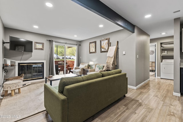 1061 W Beaver Creek Blvd Unit F101, Avon, CO 81620 - living area featuring washer / dryer, a glass covered fireplace, light wood-style flooring, recessed lighting, and baseboards