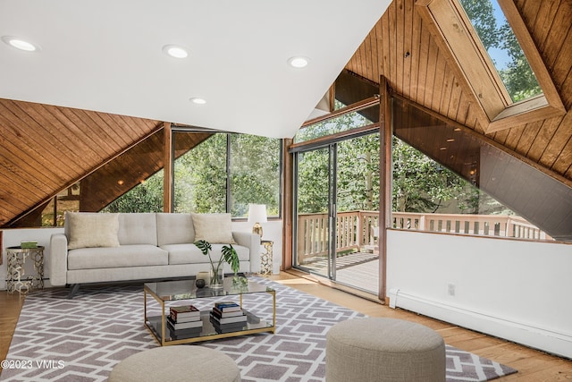 living room with a wealth of natural light, lofted ceiling with skylight, and a baseboard radiator