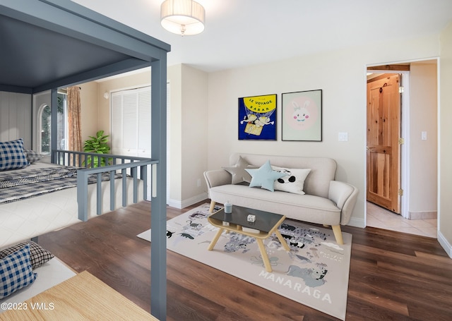 living area with baseboards and wood finished floors