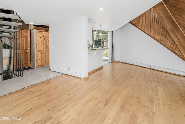 unfurnished living room featuring baseboard heating, baseboards, and light wood-style floors