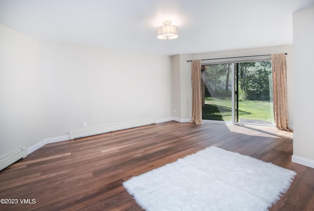 empty room with baseboard heating, baseboards, and wood finished floors
