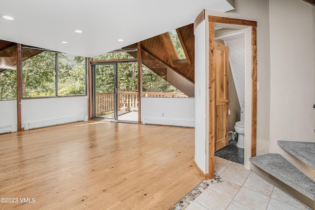 additional living space with baseboard heating, recessed lighting, and wood finished floors