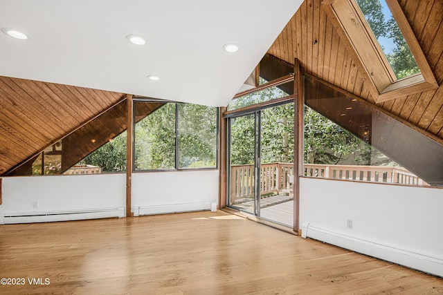 bonus room featuring baseboard heating and vaulted ceiling with skylight