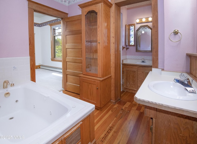 409 Washington St, Eagle, CO 81631 - full bathroom with a sink, baseboard heating, a tub with jets, and hardwood / wood-style flooring