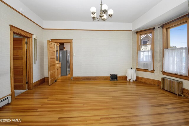 409 Washington St, Eagle, CO 81631 - spare room featuring radiator heating unit, a chandelier, light wood-type flooring, and baseboards
