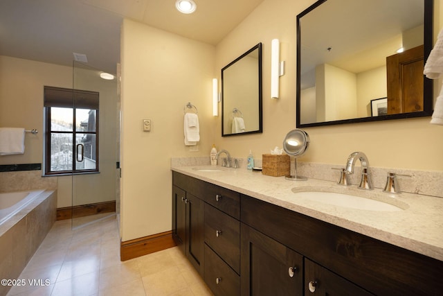 bathroom featuring a relaxing tiled tub, tile patterned floors, and vanity