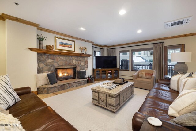 living room with ornamental molding, a fireplace, a baseboard radiator, and light hardwood / wood-style floors