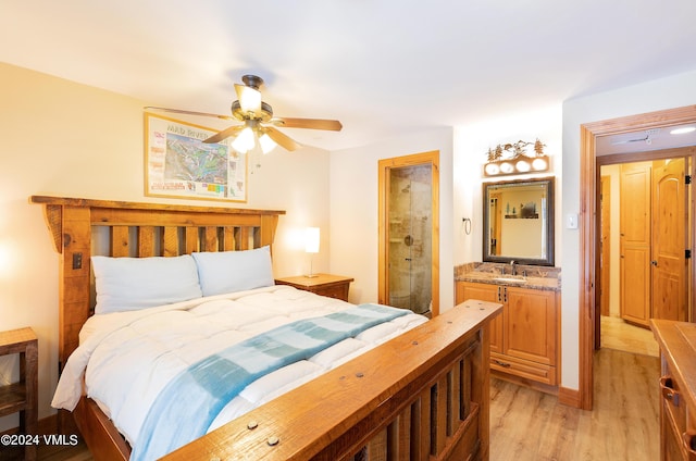 bedroom with ensuite bathroom, sink, and light hardwood / wood-style flooring