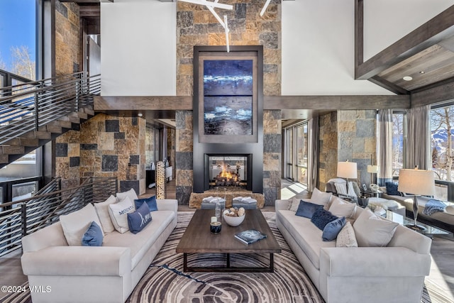 living room with beamed ceiling, a multi sided fireplace, and high vaulted ceiling