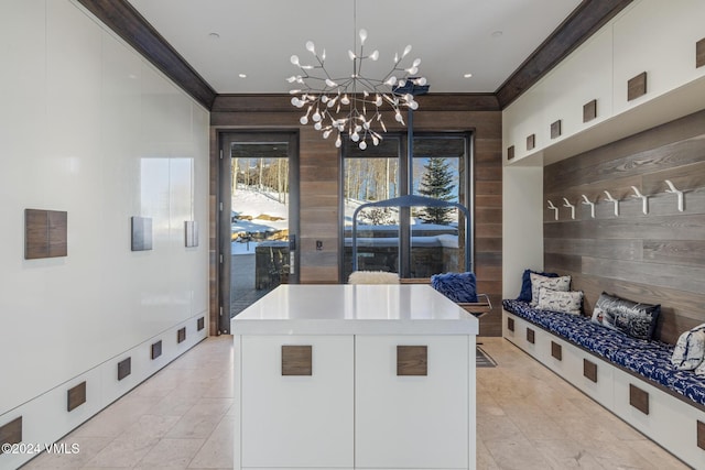 mudroom featuring a notable chandelier, wood walls, and ornamental molding