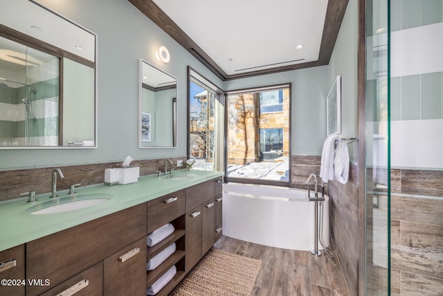 full bathroom with double vanity, a shower stall, wood finished floors, and a sink