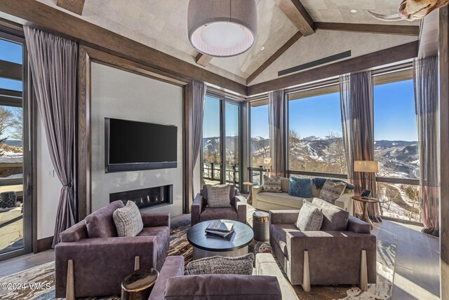 living room with wood finished floors, a fireplace, and vaulted ceiling with beams