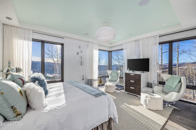 bedroom with multiple windows and wood finished floors