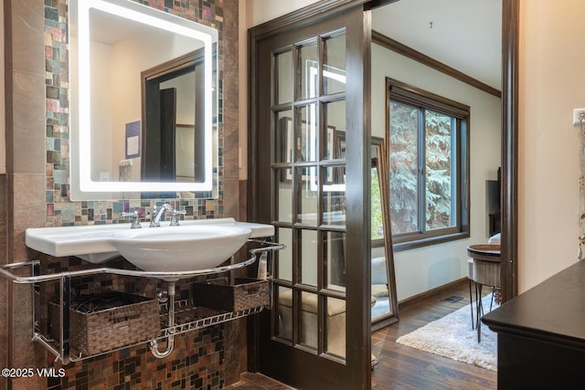 103 Meile Ln, Edwards, CO 81632 - bathroom with crown molding, wood finished floors, a sink, baseboards, and tasteful backsplash