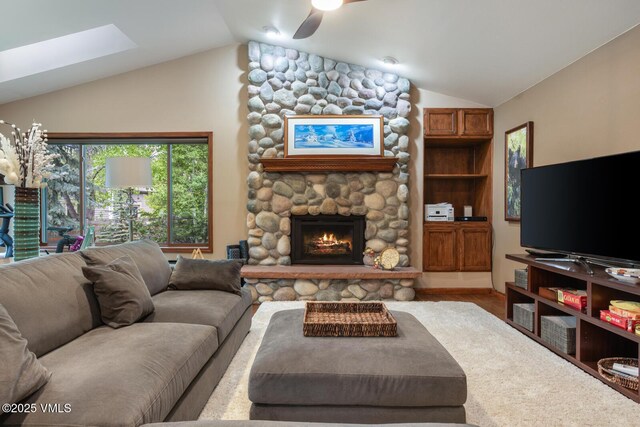 103 Meile Ln, Edwards, CO 81632 - living area with vaulted ceiling, a stone fireplace, a ceiling fan, a skylight, and wood finished floors