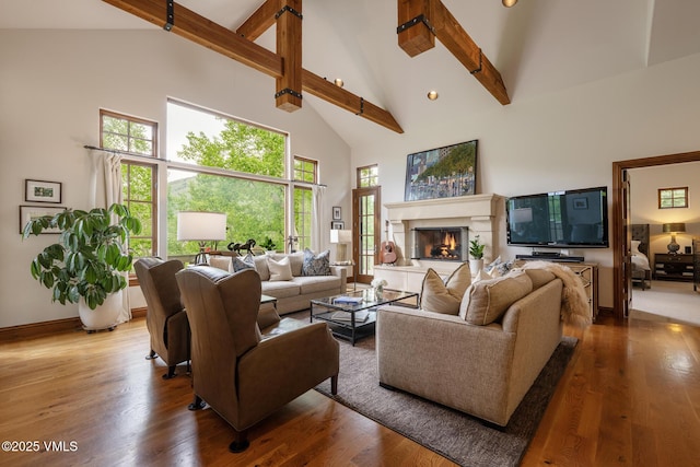 2241 Tahoe Dr, Vail, CO 81657 - living area featuring high vaulted ceiling, wood finished floors, a glass covered fireplace, beamed ceiling, and baseboards