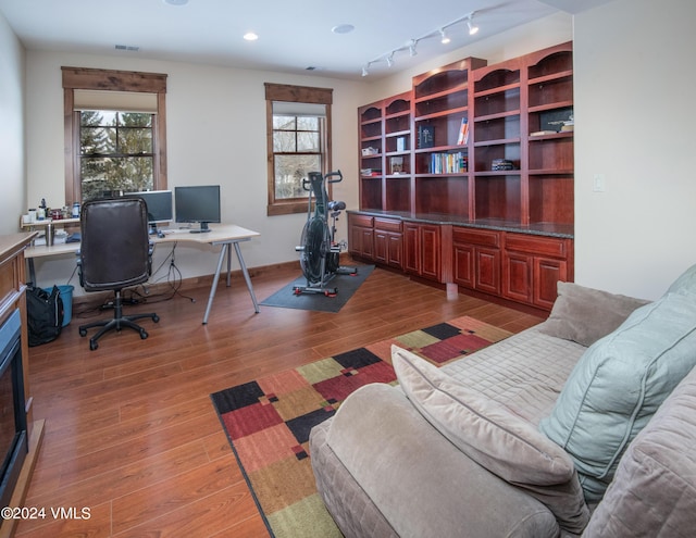 home office with recessed lighting, plenty of natural light, baseboards, and wood finished floors