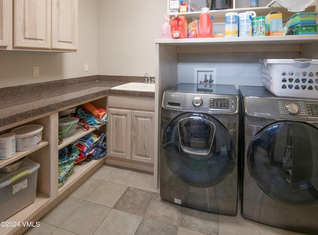 laundry area featuring light tile patterned flooring, a sink, cabinet space, and washer and dryer