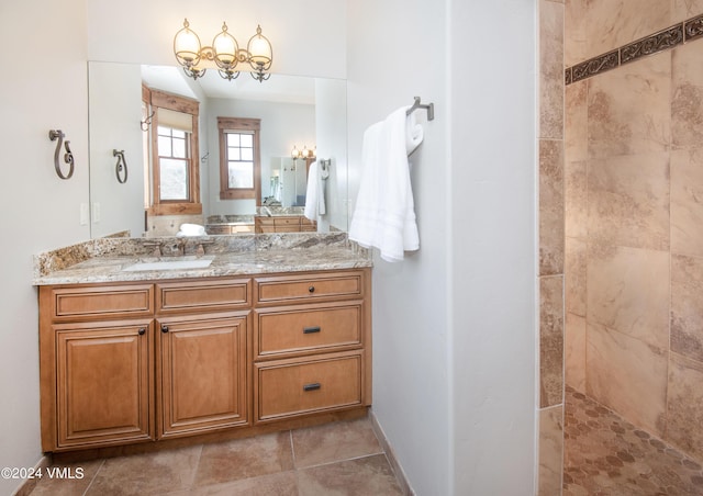 bathroom with baseboards, walk in shower, vanity, and tile patterned floors