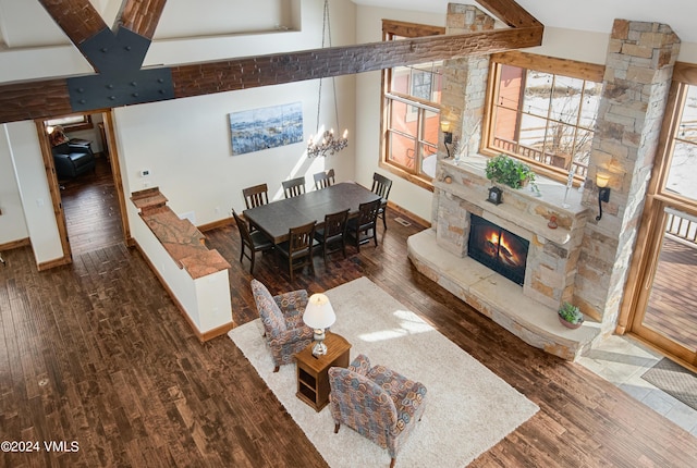 dining space with a chandelier, a fireplace, high vaulted ceiling, and wood finished floors