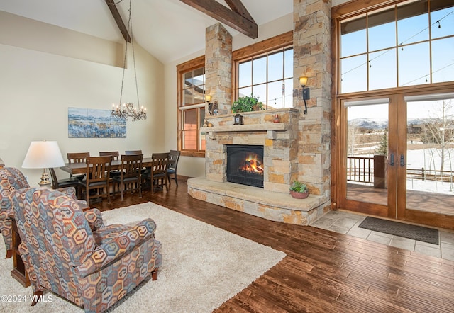 living room with high vaulted ceiling, a wealth of natural light, beam ceiling, and wood finished floors