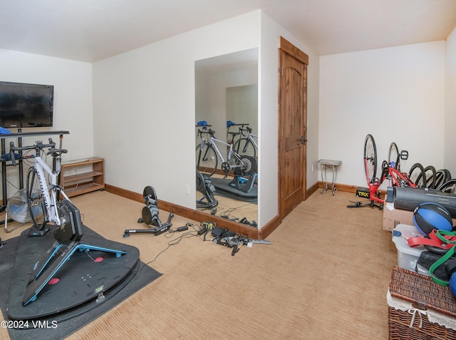 exercise room with carpet and baseboards