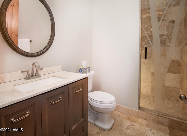 bathroom featuring toilet, a stall shower, vanity, and baseboards