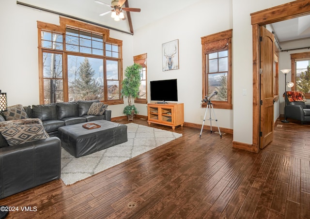 living area with a ceiling fan, dark wood finished floors, and baseboards