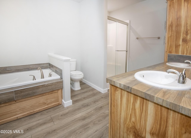 full bathroom with a garden tub, toilet, a sink, and a stall shower