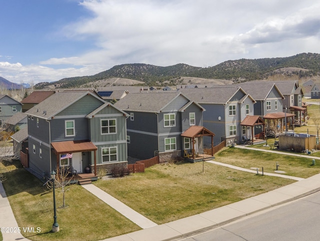 view of front of house featuring a residential view, a mountain view, a garage, board and batten siding, and a front yard