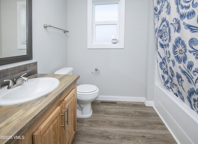 bathroom featuring toilet, wood finished floors, vanity, baseboards, and visible vents