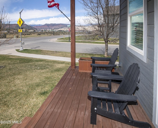deck featuring a lawn and a mountain view