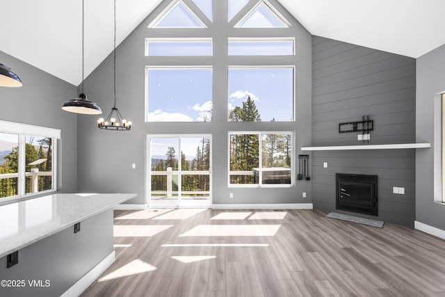 408 El Lobo Ln, Fairplay, CO 80440 - unfurnished living room with high vaulted ceiling, a large fireplace, wood finished floors, and a chandelier