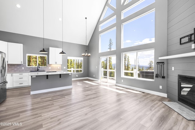 408 El Lobo Ln, Fairplay, CO 80440 - kitchen with high vaulted ceiling, open floor plan, light countertops, a kitchen island, and white cabinetry