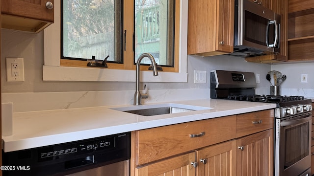 kitchen featuring stainless steel appliances, brown cabinets, a sink, and open shelves