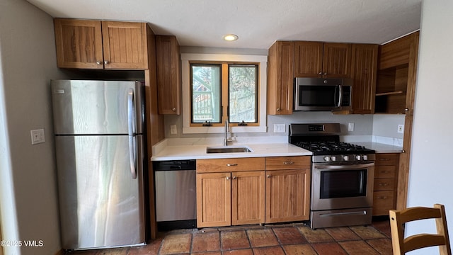 kitchen with stainless steel appliances, brown cabinetry, light countertops, and a sink