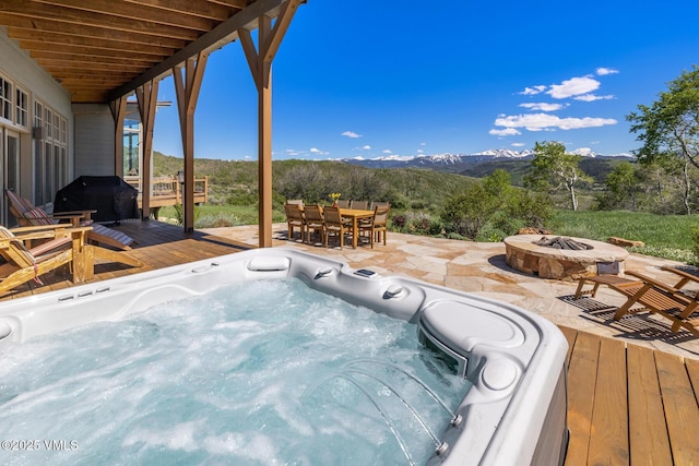 6306 Bellyache Ridge Rd, Wolcott, CO 81655 - deck with an outdoor fire pit, a mountain view, a patio area, a hot tub, and outdoor dining space