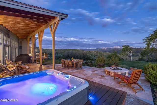 6306 Bellyache Ridge Rd, Wolcott, CO 81655 - wooden deck featuring a hot tub, an outdoor fire pit, outdoor dining space, a mountain view, and a patio area