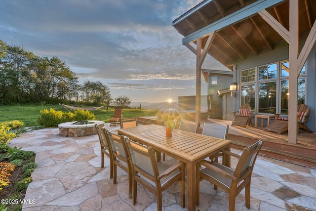 6306 Bellyache Ridge Rd, Wolcott, CO 81655 - patio terrace at dusk featuring a fire pit, a deck, outdoor dining area, and a patio